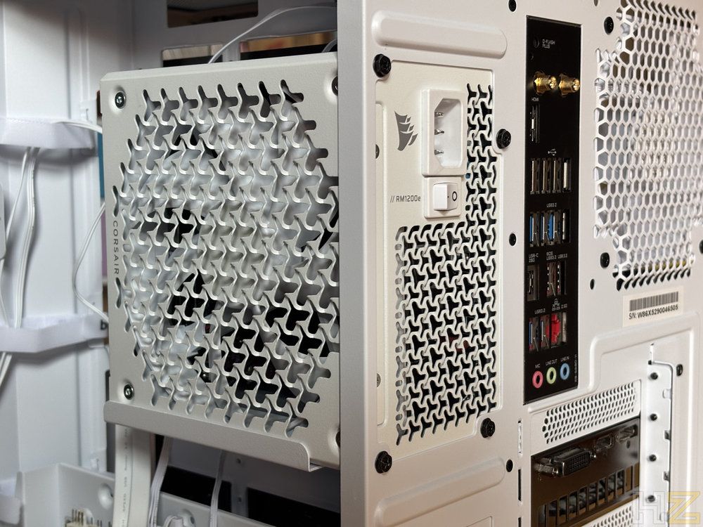 Fuente de alimentación Corsair RM1200e instalada en el lateral de un chasis de PC blanco.