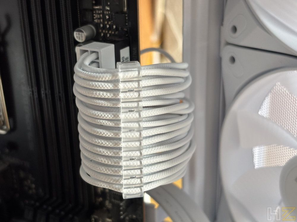 Primer plano de los cables modulares blancos conectados a una placa base con peine transparente para ordenación.