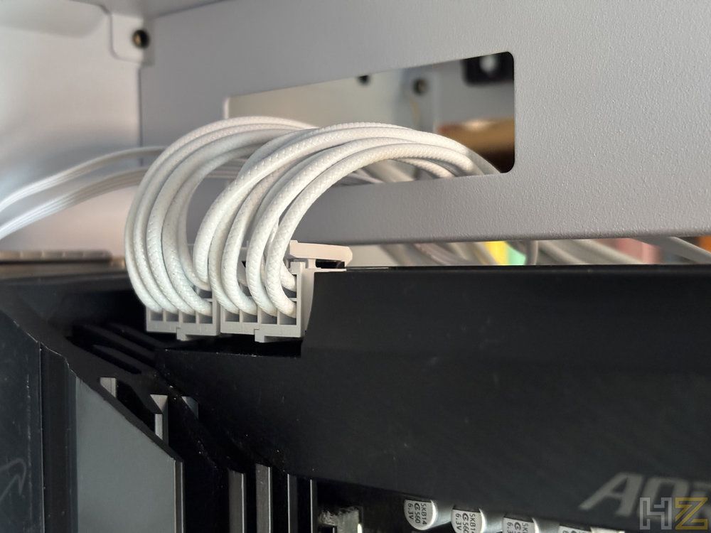 Conexión de cables blancos de alimentación en la parte superior de una placa base dentro de un chasis.