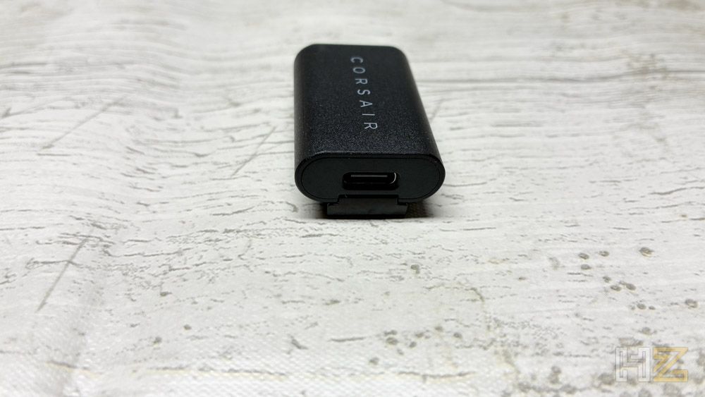 Adaptador inalámbrico USB Corsair con puerto USB-C frontal sobre una superficie clara.