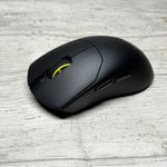 Ratón inalámbrico Corsair Sabre v3 Pro Ultralight Wireless de color negro sobre una superficie de madera clara.