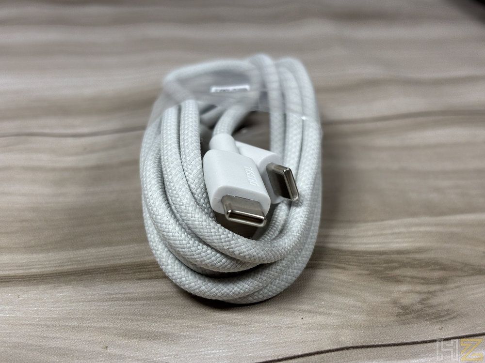 Primer plano de un cable USB-C con acabado trenzado en color gris claro, incluido con el portátil T15RA.