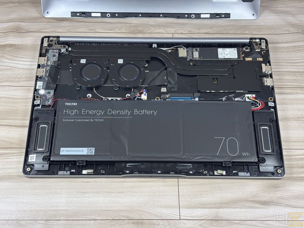 Interior de un portátil MEGABOOK T15RA con la carcasa abierta mostrando la batería de 70 Wh, ventiladores y componentes internos.