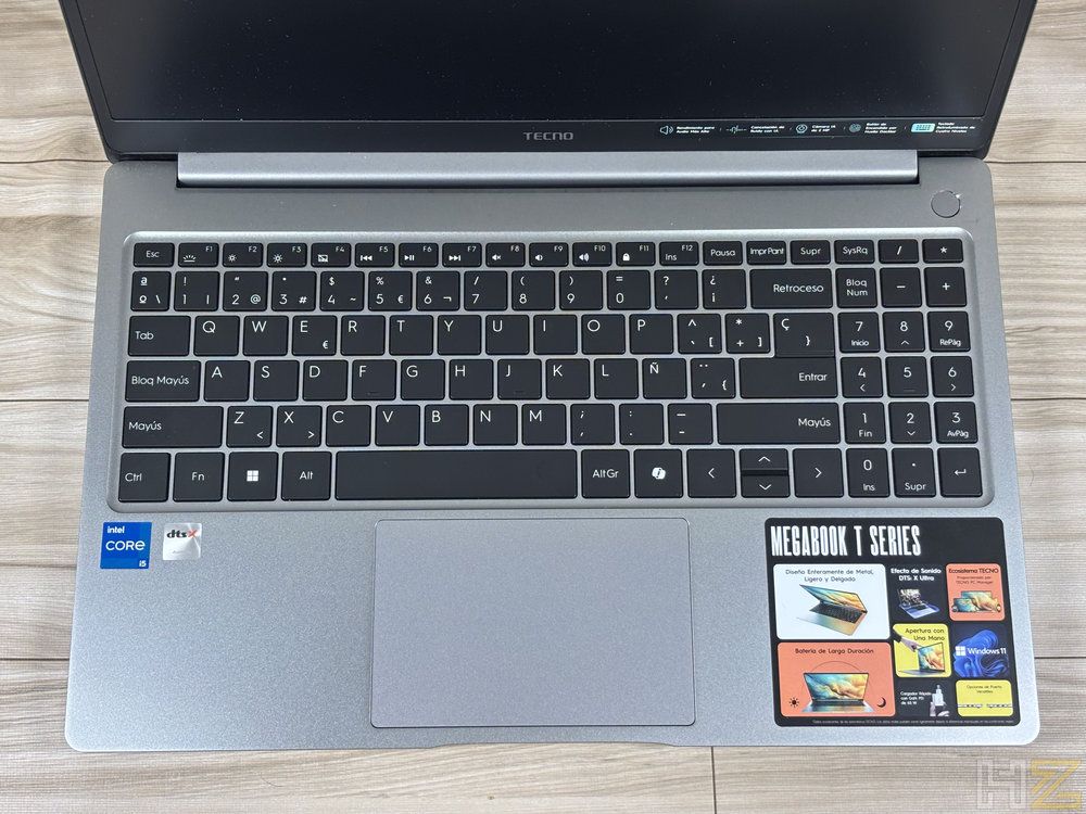 Vista cenital del teclado completo y panel táctil del ordenador portátil MEGABOOK T15RA sobre una superficie de madera.