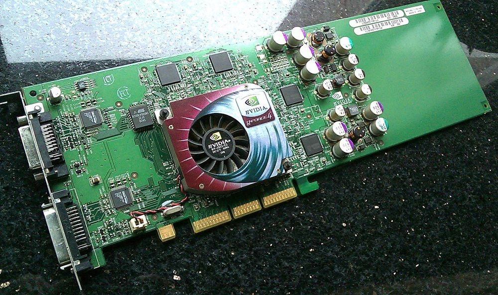 Placa de circuito verde de una tarjeta gráfica GeForce4 Ti 4600 para ordenadores Mac con su ventilador central y conectores traseros.