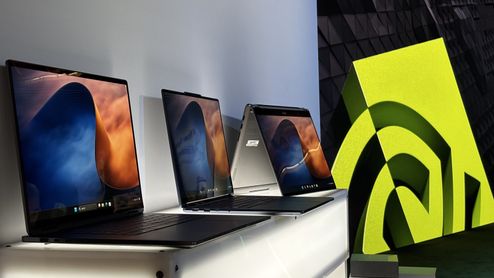 Tres ordenadores portátiles expuestos en un stand junto al logotipo de NVIDIA.