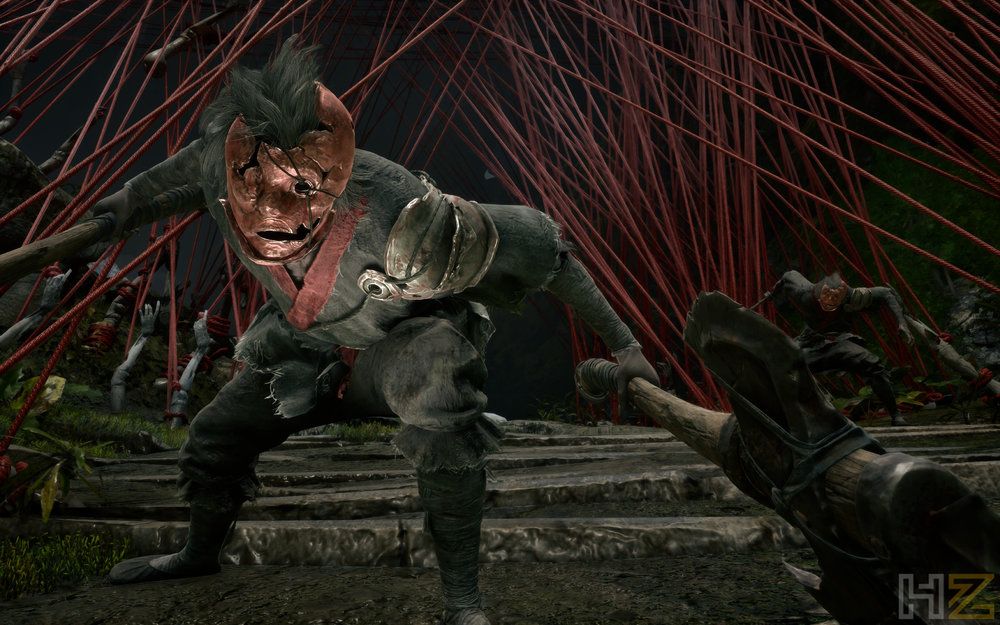 Enemigo con máscara roja de aspecto grotesco portando un arma de gran tamaño en Phantom Blade Zero.