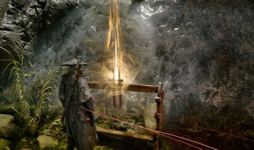 Protagonista de Phantom Blade Zero frente a un altar con espadas y efectos de luz en una cueva.