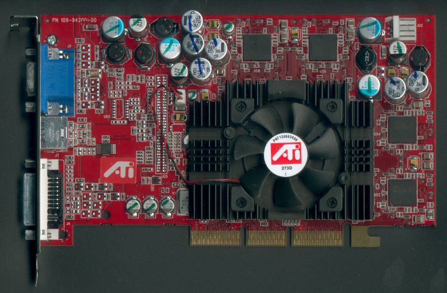 Placa de circuito impreso roja de una tarjeta gráfica ATI Radeon 9700 con su ventilador central y componentes electrónicos.