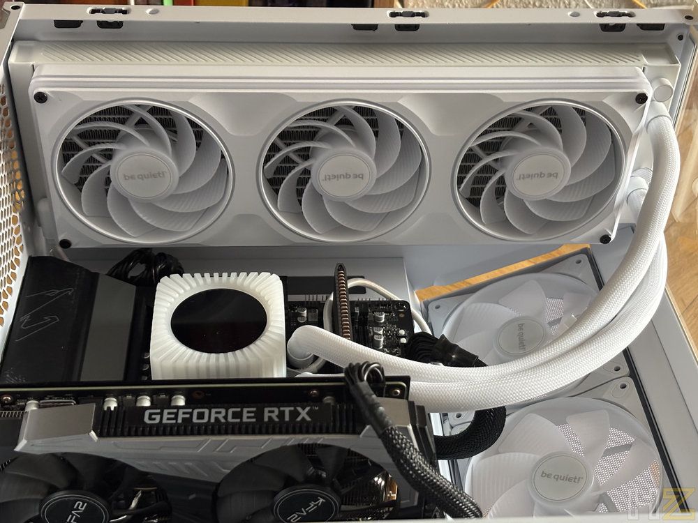 Interior de un PC blanco con el sistema de refrigeración líquida be quiet! Light Loop instalado junto a una tarjeta gráfica GeForce RTX.