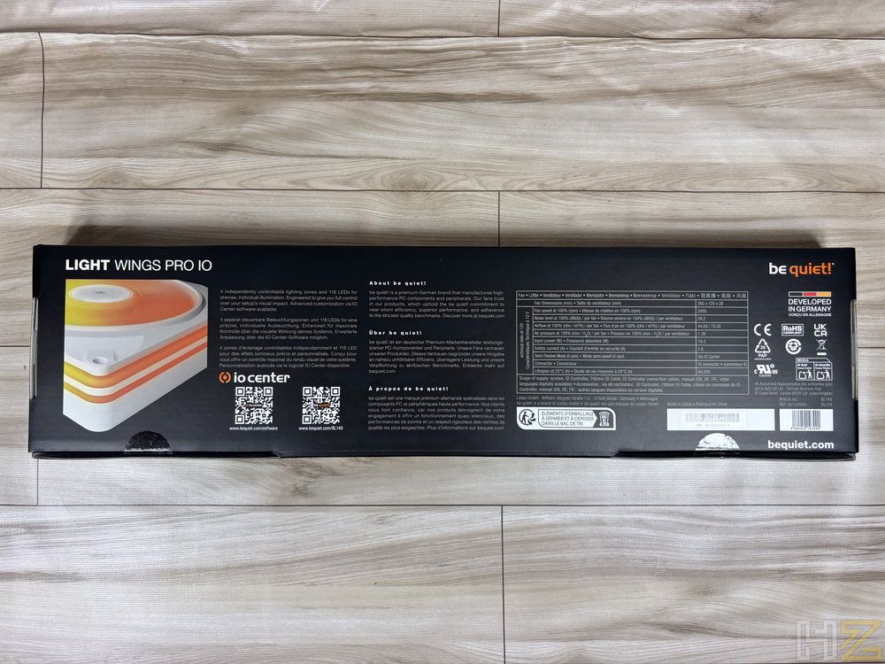 Parte trasera de la caja del be quiet! Light Wings Pro IO con especificaciones técnicas y códigos QR sobre una superficie de madera.