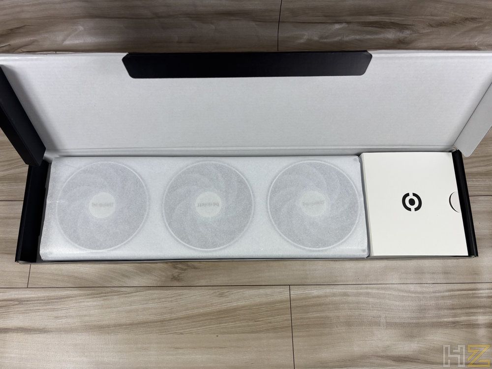 Interior de la caja de un pack de tres ventiladores be quiet! Light Wings Pro IO 04 con sus protecciones blancas y accesorios.