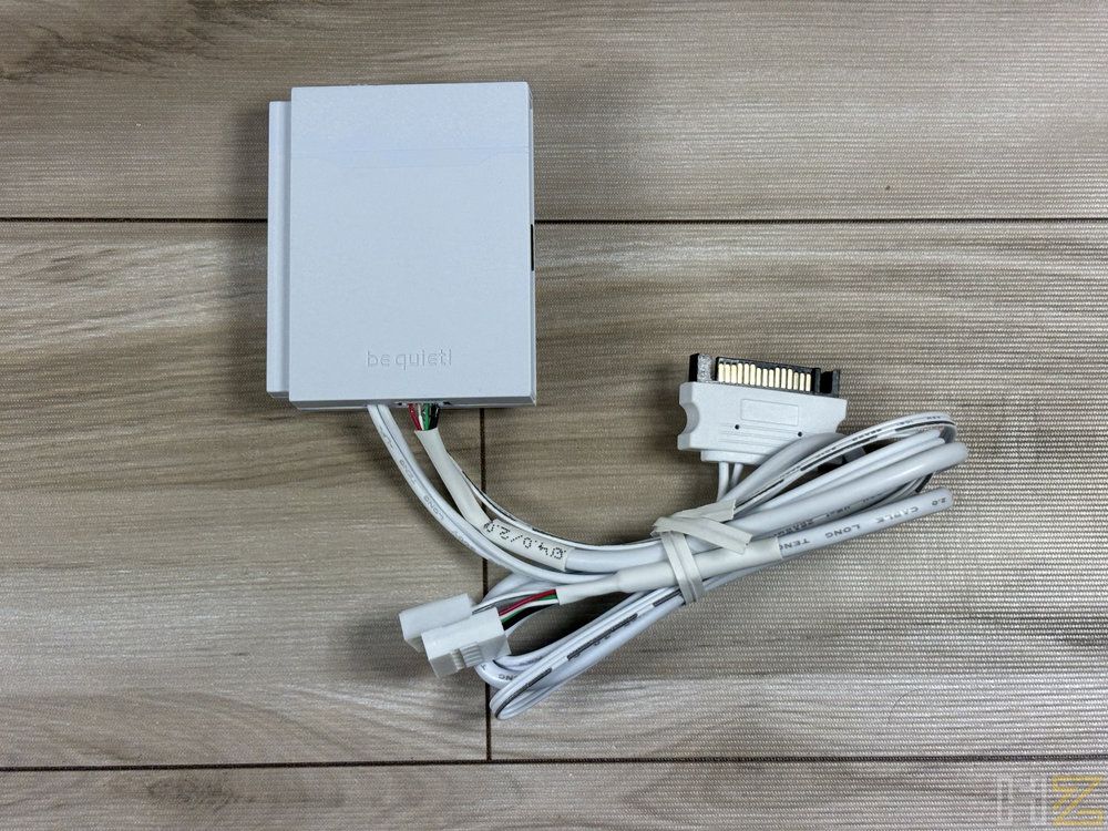 Concentrador ARGB y PWM de color blanco con su cableado correspondiente sobre una superficie de madera.
