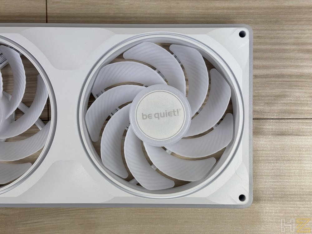 Primer plano de los ventiladores be quiet! Light Wings Pro en color blanco montados sobre una superficie de madera.
