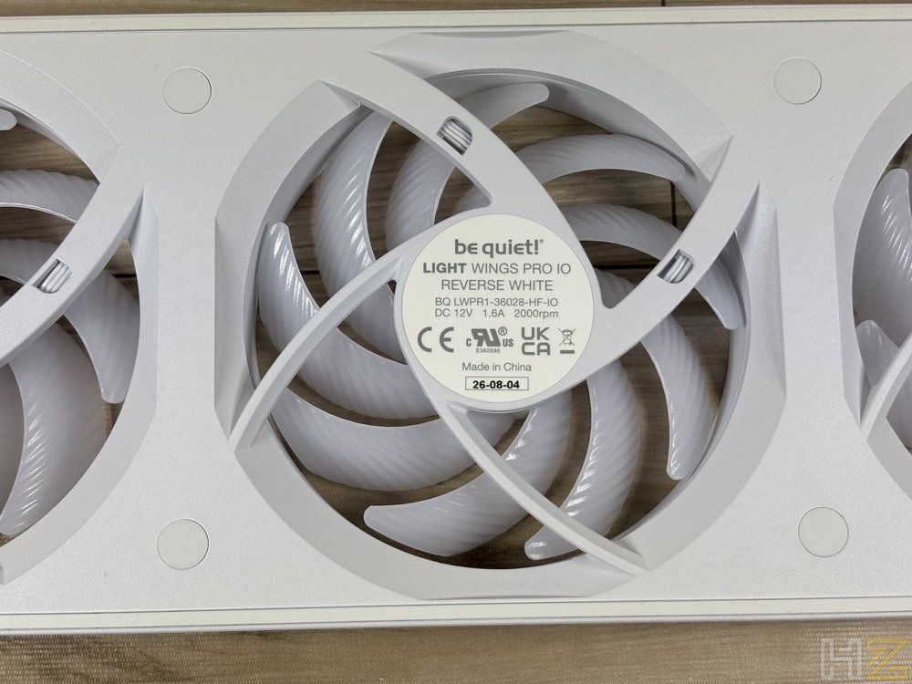 Primer plano del ventilador be quiet! Light Wings Pro IO Reverse White instalado en un chasis, mostrando la etiqueta central y las aspas blancas.