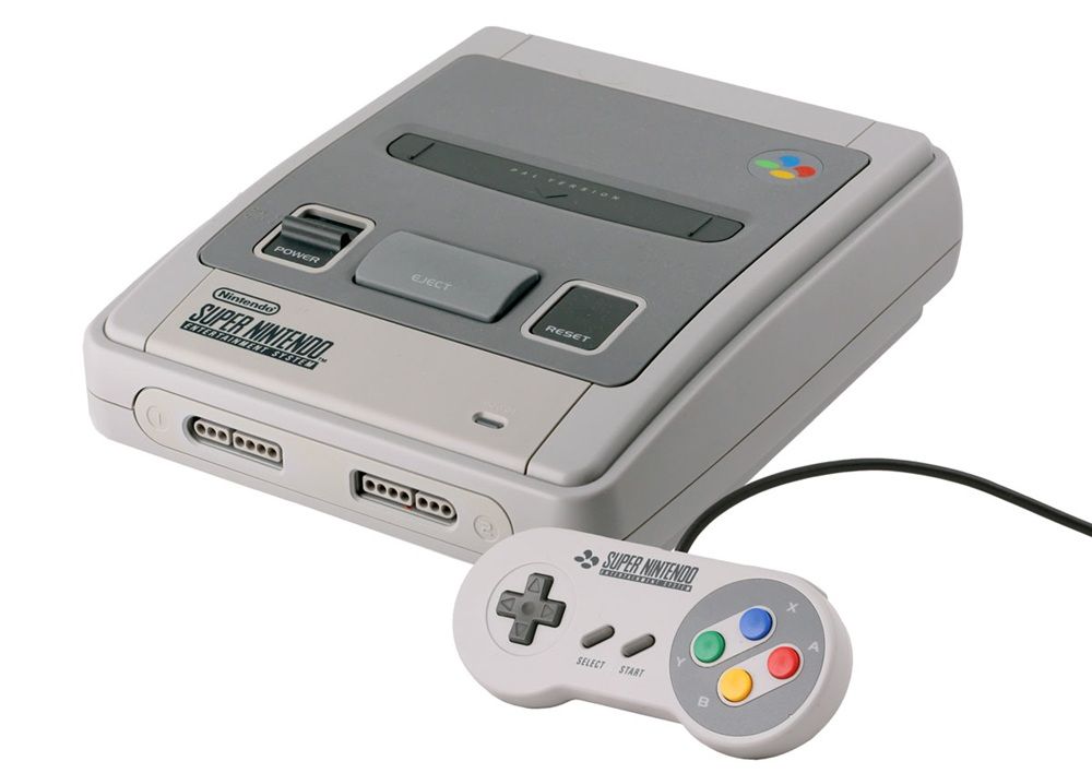 Consola Super Nintendo Entertainment System con su mando oficial de botones de colores sobre fondo blanco.