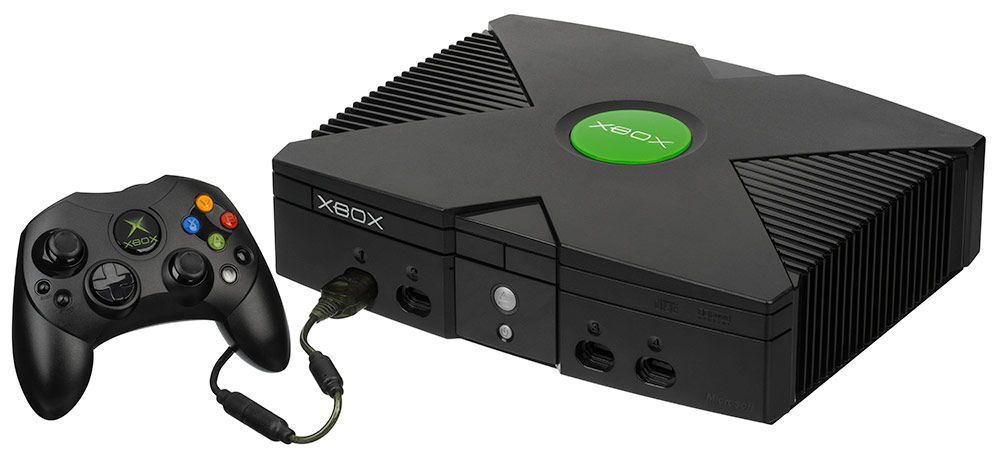 Consola original Xbox de color negro con su mando conectado sobre un fondo blanco.