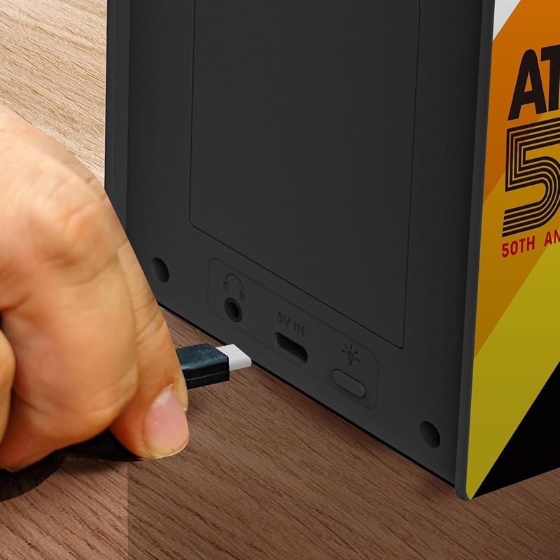 Primer plano de la parte trasera de una consola My Arcade Atari Micro donde se aprecia el conector de alimentación y la toma de auriculares.