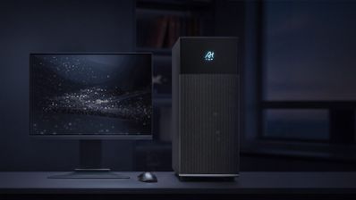 Ordenador de sobremesa Gigabyte junto a un monitor y ratón en un escritorio con iluminación tenue.