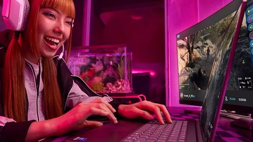 Una mujer joven con auriculares gaming blancos utiliza un ordenador portátil Intel de gama alta en una habitación con iluminación LED rosa.