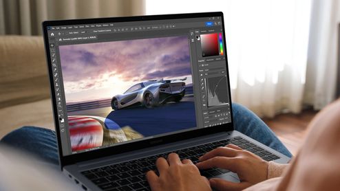 Persona utilizando un ordenador portátil Samsung Galaxy Book4 para editar la fotografía de un coche deportivo con un software de retoque profesional.