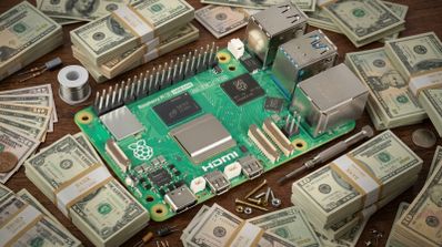 Placa Raspberry Pi rodeada de fajos de billetes de cien dólares, herramientas electrónicas y estaño sobre una superficie de madera.