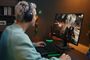 Usuario con auriculares Razer Barracuda v2 frente a un monitor gaming con un videojuego de acción.