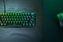 Teclado Razer Huntsman V3 Pro con iluminación RGB verde y ratón inalámbrico sobre un escritorio de madera oscura.