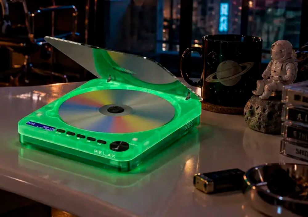Reproductor de CD Pixel Tunes After Hours con chasis transparente iluminado en color verde sobre un escritorio nocturno.