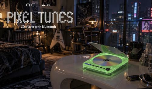 Reproductor de CD Pixel Tunes con iluminación verde en una habitación con vistas nocturnas a la ciudad.