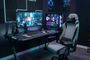 Silla gaming Newskill Neith Zephyr situada frente a un escritorio con PC, monitor ultrapanorámico e iluminación RGB.