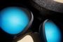 Primer plano del interior de unas gafas de realidad virtual mostrando las lentes iluminadas en color azul.