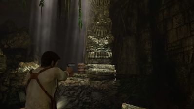 Nathan Drake apunta con un arma en una ruina subterránea con estatuas de piedra en Uncharted PC.