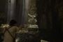 Nathan Drake apunta con un arma en una ruina subterránea con estatuas de piedra en Uncharted PC.